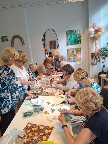 Seniorki podczas pracy twórczej nad decoupage przy stole