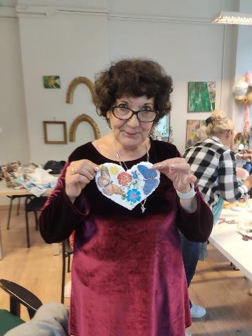 Uczestniczka warsztatów prezentująca ozdobione serce decoupage